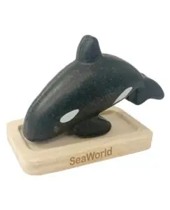 A black and white orca whale on top of a wooden block.