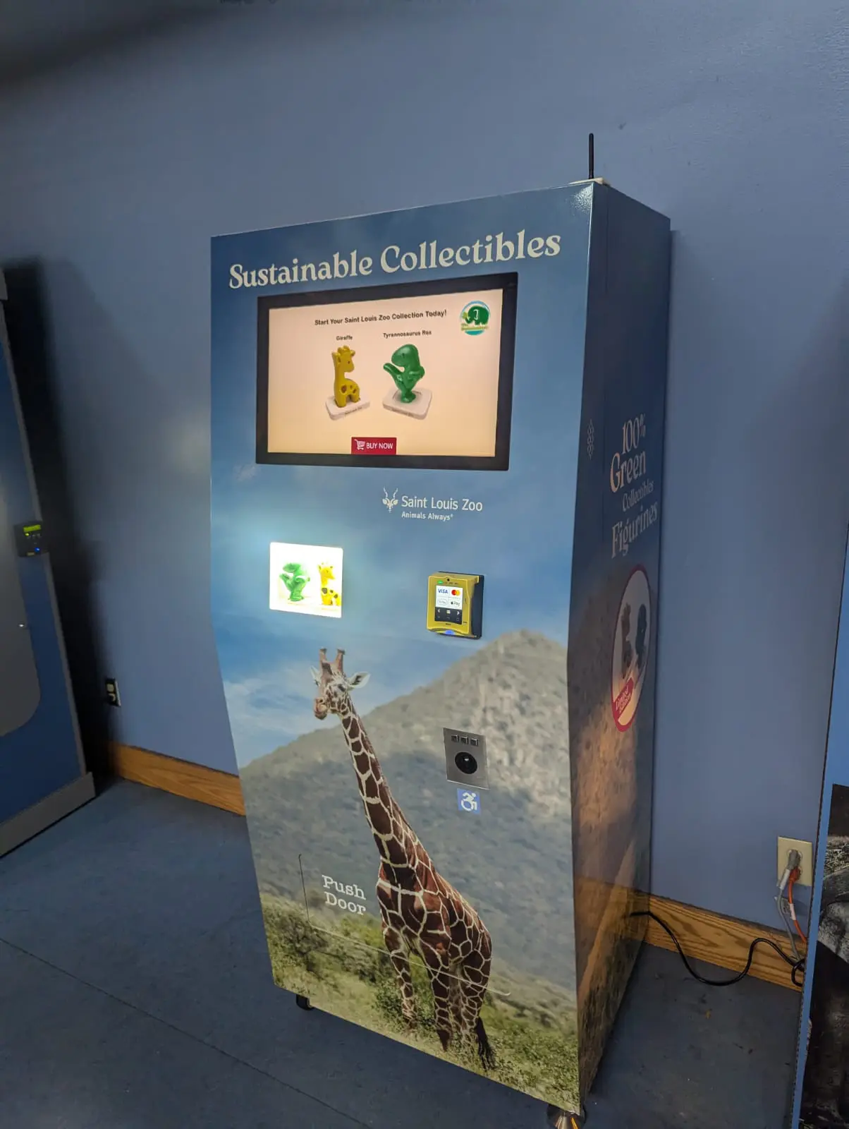 A giraffe standing next to a wall with a sign on it.
